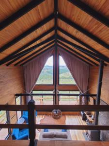 um quarto com uma grande janela e um tecto de madeira em Cerro Leão Estância- chalé em Bom Jardim da Serra