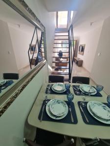 uma sala de jantar com uma mesa com pratos em Apt 17 com 2 suítes com ar cond em Montes Claros