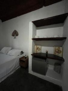 a bedroom with a bed and a shelf on the wall at Pousada Chalés da Lua in Munhoz