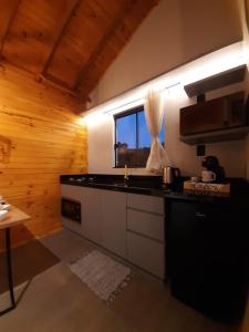 uma cozinha com um balcão e uma janela em Pousada Recanto da Cascata - Cabana Platano em São Joaquim