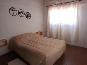 Habitación pequeña con cama y ventana en Dúplex en Mendoza