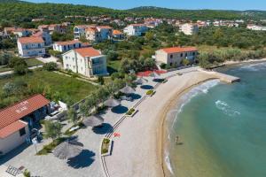 an aerial view of a beach with umbrellas at Apartments by the sea Kraj, Pasman - 17783 in Tkon