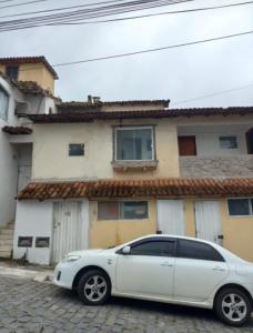 a white car parked in front of a house at Antonia Hospedaria 2 in Búzios
