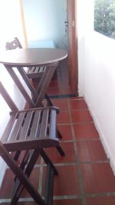 a table and a chair sitting on a floor at Antonia Hospedaria 2 in Búzios