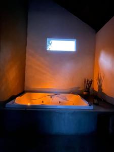 a bath tub in a room with a window at Pousada Chalés da Lua in Munhoz