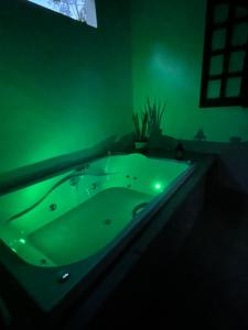 a green bath tub in a green room at Pousada Chalés da Lua in Munhoz