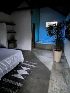 a bedroom with a bed and a potted plant at Pousada Chalés da Lua in Munhoz