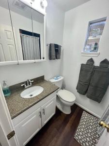 a white bathroom with a sink and a toilet at Morse Cottage in Houston
