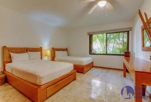 1 dormitorio con cama y ventana en Chac Hal, Beachfront Apartment with Amenities - Chac Hal 2, en Puerto Aventuras