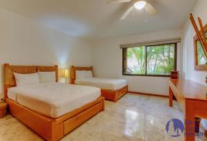 プエルト・アベントゥラスにあるChac Hal, Beachfront Apartment with Amenities - Chac Hal 2のベッドと窓のある寝室