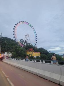 a ferris wheel on a bridge over a highway at Suítes Aconchego Sol e Mar in Navegantes