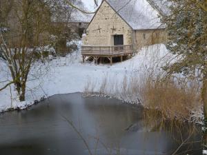 eine alte Scheune im Schnee neben einem Teich in der Unterkunft Gîte Chilleurs-aux-Bois, 2 pièces, 2 personnes - FR-1-590-276 in Chilleurs-aux-Bois