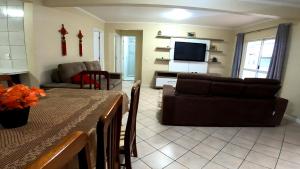 a living room with a couch and a television at 124 - Apartamento 3 dormitórios condomínio fechado in Bombinhas
