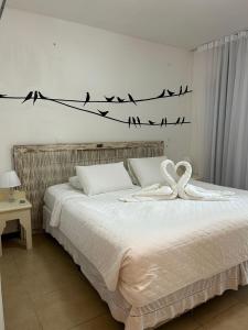 Un dormitorio con una cama con pájaros en un cable en Casa 70 Mar Paraíso, en Porto Seguro