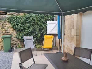 a table and chairs under an umbrella on a patio at Charmant gîte avec terrasse près du Lac de Madine, idéal pour 2 à 4 personnes - FR-1-585-90 in Buxières-sous-les-Côtes