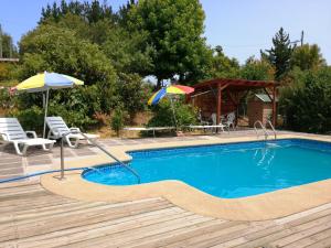 a swimming pool with two umbrellas and a table and chairs at Cabaña Quillón El Campito in Quillón