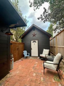 a patio with two chairs and a shed at Morse Cottage in Houston
