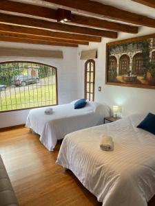 1 Schlafzimmer mit 2 Betten und einem großen Fenster in der Unterkunft Hacienda Turística La Morería in Amaguaña
