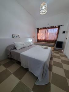 - une chambre avec un grand lit blanc et une fenêtre dans l'établissement MG Suites, à Monte Grande