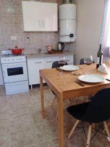 a kitchen with a table and two glasses of wine at My House in El Calafate. in El Calafate