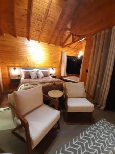 um quarto com uma cama, uma mesa e cadeiras em Pousada Recanto da Cascata - Cabana Liquidambar em São Joaquim