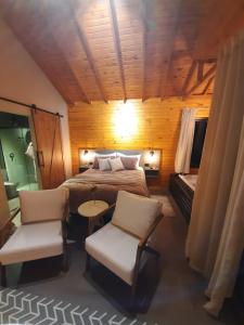 um quarto com uma cama, uma mesa e cadeiras em Pousada Recanto da Cascata - Cabana Liquidambar em São Joaquim