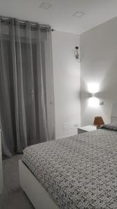 um quarto branco com uma cama e uma janela em Casa vacanze Hoffman em Caltagirone