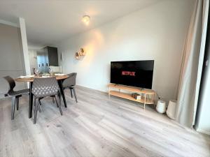 uma sala de estar com uma mesa de jantar e uma televisão em New Selfoss Apartment - Stylish & Modern em Selfoss