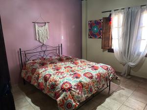 sypialnia z łóżkiem z kolorową kołdrą w obiekcie Casa de Campo LA MEDALLA w mieście Médano de Oro