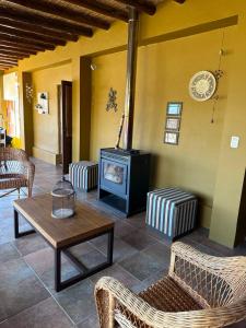 een woonkamer met een open haard en rieten meubels bij Casa de Campo LA MEDALLA in Médano de Oro