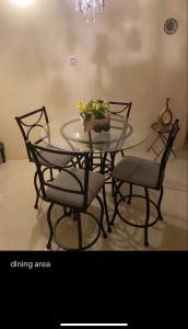 a glass table with chairs and a bowl of flowers on it at 2 Bedroom Apt Falmouth in Florence Hall