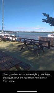 a row of picnic tables on a dock near the water at 2 Bedroom Apt Falmouth in Florence Hall
