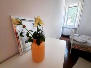 an orange vase with yellow flowers on a table at Old Town Central 2 Bedroom Oasis in Timişoara