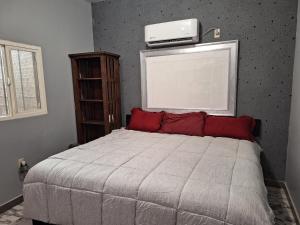 um quarto com uma cama e uma televisão na parede em MercedesHouse em Hermosillo