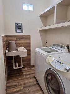 a laundry room with a washing machine and a sink at MercedesHouse in Hermosillo