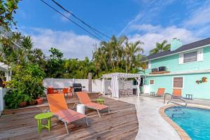 a deck with chairs and a swimming pool at Walk to the beach - Island Villa in Siesta Key