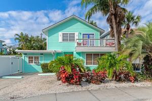 uma casa azul com uma varanda e palmeiras em Walk to the beach - Island Villa em Siesta Key