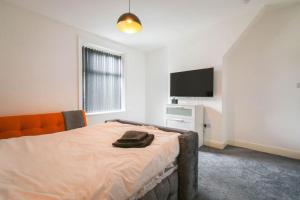 a bedroom with a bed and a flat screen tv at Home in the Heart of Accrington in Church