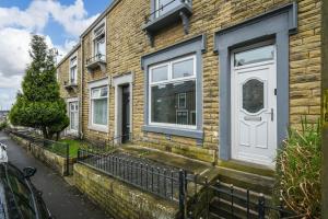 a brick house with a white door on a street at Home in the Heart of Accrington in Church