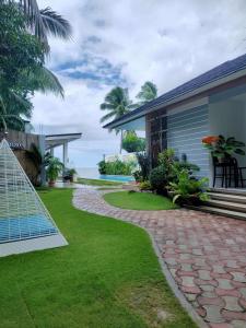 ein Haus mit einem Garten und einem Gehweg in der Unterkunft Sea Horizon Resort in Zamboanguita