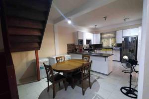 a large kitchen with a wooden table and chairs at Luxurious 4-bedroom home in serene community in Roseau