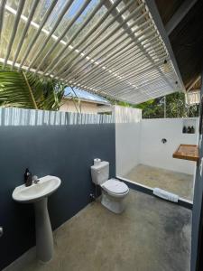a bathroom with a toilet and a sink at Grand Park Manuel Antonio - Adults Only in Manuel Antonio