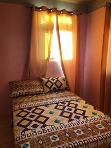 a bedroom with a bed with a quilt on it at Luxurious 4-bedroom home in serene community in Roseau