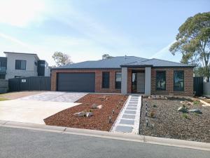 a house with a garden in front of it at Captains Edge- Brand New 3 bedroom spacious home, private afresco & yard central to Paynesville CBD in Paynesville
