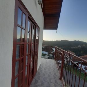 a balcony with a door and a view of a building at Casa Bela Vista in Campos do Jordão