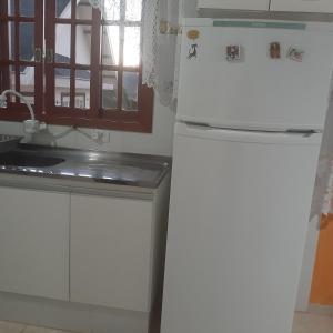 uma cozinha com um frigorífico e um lavatório em Casa Bela Vista em Campos do Jordão