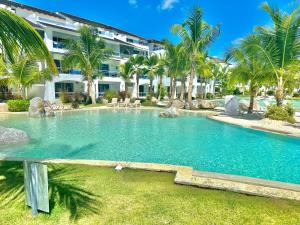 una piscina frente a un edificio con palmeras en Estrella Dominicus Advantage, en Bayahibe