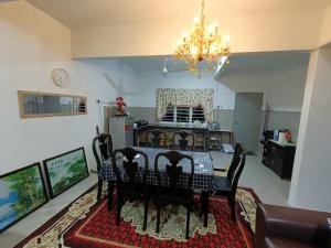 a living room with a table and chairs and a kitchen at Homestay Kesang Sungai Rambai in Kampong Sungai Rambai