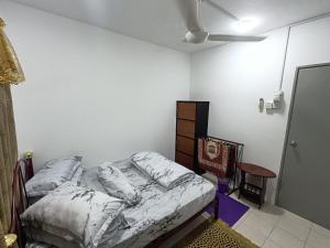 a bedroom with a bed and a chair in it at Homestay Kesang Sungai Rambai in Kampong Sungai Rambai
