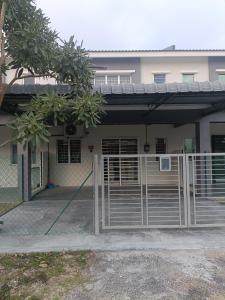 a house with a gate and a fence at Homestay Kesang Sungai Rambai in Kampong Sungai Rambai